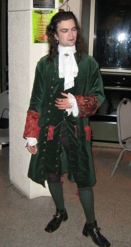 A green velvet and red figured satin frock coat with brass buttons...